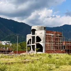 A view of the "La La Land" site, with the raw concrete structure rising against the backdrop of the hills that inspired its design.