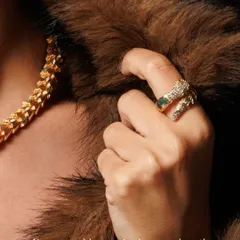 Detail is everything in luxury product photography. Here, the focus shifts to the serpent ring, complementing the necklace. The contrast between the cold metal and the soft fur highlights the piece's danger and beauty in a single frame.