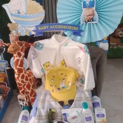 This hamper features a 'Boss Baby' theme and includes a variety of baby products and clothes, with a cute giraffe soft toy.