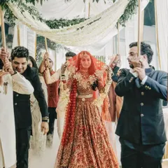 The bridal entry is a showstopper. Here, the bride walks under a 'phoolon ki chadar' held by her brothers, with smoke effects creating a dreamy, ethereal path to the mandap.
