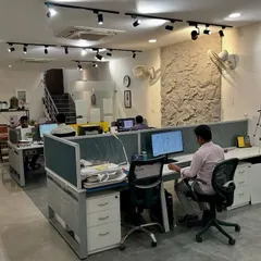 A view of our architecture studio in Malviya Nagar. We designed our own office with an open layout to foster collaboration among the team. The track lighting and exposed stone wall add character to the space.