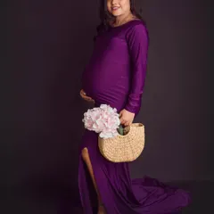 A side profile showcasing our stunning purple gown. This pose is perfect for highlighting the beautiful curve of the baby bump.