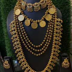 This antique-finish set includes a coin necklace (Putli Haar) and a traditional choker, perfect for a royal look.