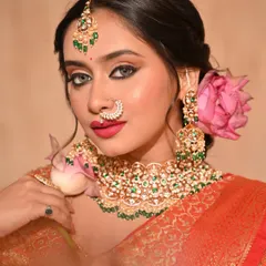 A modern bridal hairstyle featuring a beautiful messy bun adorned with a fresh lotus flower. This unique touch adds a soft, romantic, and personal element to the traditional look.