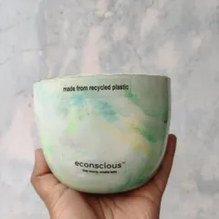This beautiful bowl-shaped planter, with its soft green and yellow marble pattern, is made from 150 grams of recycled plastic. It's a perfect home for a small plant and a great conversation starter.