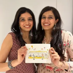 A picture of us, Kamakshi and Vishala, holding a beautiful illustration of our 'Sound Space on Wheels' bus. This drawing captures the heart of our fundraiser and our mission to bring music to all.