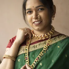 A beautiful client wearing a traditional Maharashtrian set featuring a Thushi choker and a matching long necklace. This is a classic look for any festive occasion.