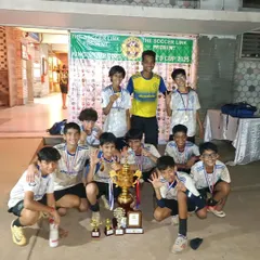 Our victorious U13 team celebrates with their coach and the winner's trophy after a hard-fought tournament. Their smiles and cheers capture the pure joy of winning as a team.