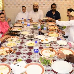 Guests enjoying a meal together at one of our long dastarkhwan setups. This seating arrangement is perfect for larger groups and fosters a wonderful sense of community.