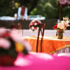An atmospheric shot of a daytime event, with colorful table settings and floral arrangements creating a beautiful, soft-focus background.