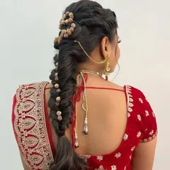 Our curriculum also includes bridal hairstyling. Here, you can see an intricate fishtail braid adorned with hair accessories, a popular choice for modern North Indian brides.