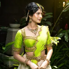 This 92.5 silver jewellery set with an antique gold finish is perfect for a mehendi or sangeet. The green and red stones add a pop of color to the lime green and white lehenga.