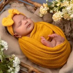 Another take from the yellow floral basket session, this time with a focus on the baby's perfectly swaddled form and the soft textures of the setup.