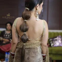A back view of a modern and stylish bubble ponytail. This hairstyle is perfect for a reception or cocktail party and adds a fun, contemporary twist to any outfit.