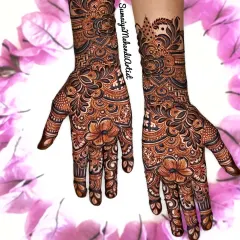 This is a beautiful example of a full and festive design, perfect for a sangeet or as a wedding guest. The mix of flowers and traditional motifs covers the hands beautifully.
