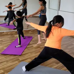 Guiding my young students in Warrior II pose. I focus on helping them find the right alignment in a way that feels empowering, building strength and stability.