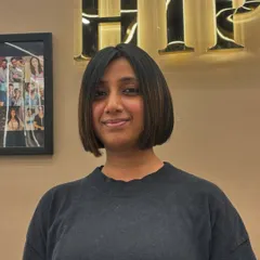 A happy client showing off her new bob. The cut is perfectly symmetrical and styled sleek and straight for a polished look.