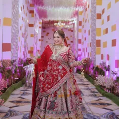 A happy bride twirls in her beautiful red lehenga, her joy radiating through the photograph.