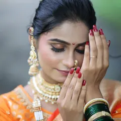 A close-up of a traditional bridal look, focusing on the soft glam eye makeup and flawless skin. Notice the details, from the perfect bindi to the classic nath.