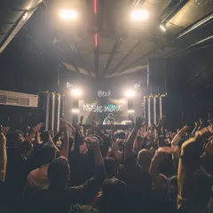 A view from the crowd at Flo, with my 'Music Monk' logo lighting up the stage. This is the scene you can expect: hands in the air and a room united by the beat.