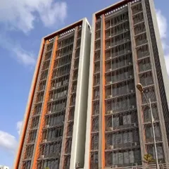 For the 'Dreams Paradise' residential building in Kharghar, we focused on clean lines and a simple, elegant facade. The design uses depth and a restrained color palette of grey and deep squash to create a sophisticated play of light and shadow.