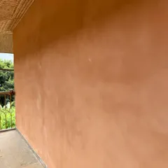 A close-up view of the smooth, even finish of the lime plaster texture on an exterior wall. The quality of the application is clear in the seamless surface.