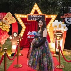 The beautiful mom-to-be, the star of the show, posing on the red carpet. I love creating themed decor that not only looks great but also makes the guests of honor feel truly special.