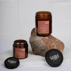 My "Wild Oudh Earth" candle has a deep, earthy, and sophisticated fragrance. Here you can see it in two sizes, both poured in amber jars that protect the fragrance oils and provide a warm, ambient glow.