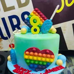 A colorful 2kg Pop It cake for an 8th birthday, with a heart and star-shaped fondant Pop It design.