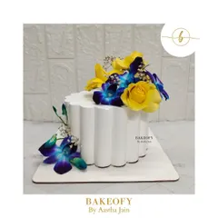 Blooms on a shell. This is my scallop-shaped cake, a unique design that provides a beautiful canvas for fresh flowers like these blue orchids and yellow roses.