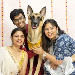 A beautiful family portrait celebrating a festival together. This German Shepherd looks so proud to be included in the festivities with his loving family, all dressed in traditional attire.