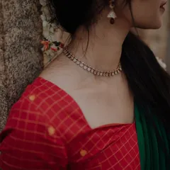 A detail shot of a traditional checked blouse and a delicate diamond necklace. The focus is kept sharp on the jewelry and fabric texture, demonstrating the quality of the products for an e-commerce listing.