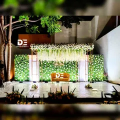 An evening reception calls for a special kind of magic. I designed this stage with a lush green floral wall, a canopy of cascading white wisterias, and elegant gold frames, all expertly lit to create a warm, sophisticated, and glamorous atmosphere after dark.