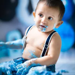 A close-up of the birthday boy, covered in blue frosting and happiness. These are the wonderfully chaotic moments that make for the best memories.