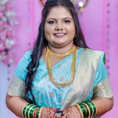 A happy, smiling close-up of the bride-to-be. This shot highlights the flawless makeup application, from the smooth base to the defined eyes and the traditional bindi, all coming together for a perfect engagement look.