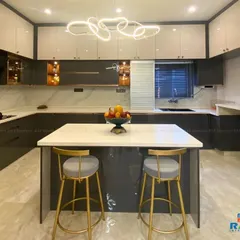We designed this modern U-shaped modular kitchen to be both a chef's delight and a family hub. It features a sleek island that doubles as a breakfast counter, high-gloss grey and white cabinets for ample storage, and a stunning designer chandelier that adds a touch of luxury.