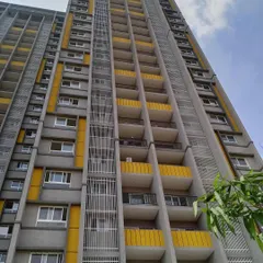 An upward-looking perspective of the Salarpuria Sattva Opus apartments, detailing the balcony design and the vertical fins that add texture to the building's face.
