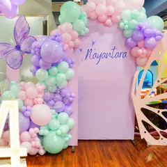 Welcome to the enchanted forest. This Fairy Garden theme features a beautiful butterfly-wing entrance, mushroom props, and a soft, magical color palette of pastel balloons.
