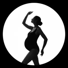 A fine art silhouette captured within a circle of light. This artistic approach creates a dramatic and memorable portrait that celebrates the beautiful shape of pregnancy.