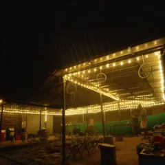 A view of the cozy seating area at a nature stay, lit up with string lights at night. Perfect for relaxing after a day of exploring.