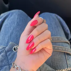 A stunning, bright magenta polish on long almond nails. This bold, glossy color makes a beautiful statement.