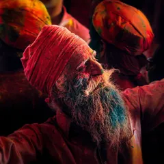 Amidst the frenzy of Holi, I captured this moment of serene joy on an elderly man's face. His beard is colored blue, and his expression is one of pure bliss, a reminder that peace can be found even in the midst of chaos.