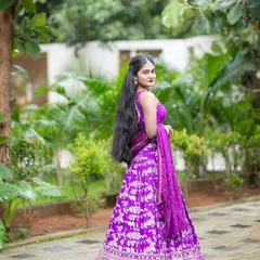 A full view of the custom purple lehenga. The sleeveless blouse and flowing skirt create a look that's both traditional and effortlessly chic.