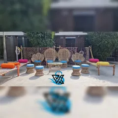 For a vibrant Mehndi, we arranged this casual seating area with traditional woven charpais and mooda chairs, adding colorful cushions for a festive and comfortable atmosphere.