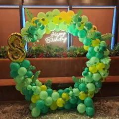 This jungle-themed circular balloon arch uses various shades of green to create a lush, leafy effect. I added a gold foil number '8' and a "Happy Birthday" neon sign to make it a perfect, on-theme photo booth for the party.