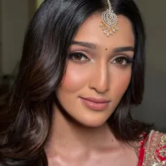 A close-up of a modern red bridal look. The focus here is on flawless skin and sharp, clean lines with a winged eyeliner and softly contoured features, proving that a traditional red lehenga can be both classic and contemporary.