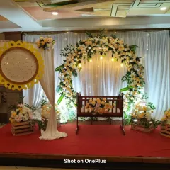 For this naming ceremony, I created a serene and beautiful space. The centerpiece is a traditional wooden cradle, framed by a lush floral arch of peach and white roses, with soft lighting to create a warm glow for the baby's big day.