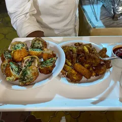 We offer a wide variety of starters to suit every palate. This tray features our crispy stuffed bread rolls and another fried specialty, served with a spicy dipping sauce.