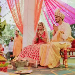 The couple seated for the wedding puja. I capture the solemnity and beauty of the rituals, focusing on their expressions as they participate in the ceremony.