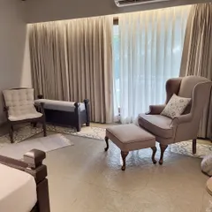 A breezy corner in an Alibaug villa, brought to life with our soft upholstery and flowing curtains. The subtle pattern on the floor rug adds a layer of texture to this serene and comfortable setting.